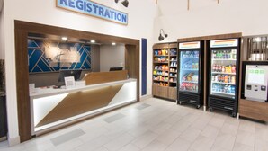 Ein Empfangsschalter mit modernem Design, eine Kühlvitrine für Getränke und ein Self-Service-Terminal.