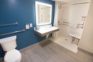 A modern bathroom with a white toilet, a sink with a mirror above it, and a shower area with a glass door. - Holiday Inn Express & Suites Ft. Lauderdale Airport West by IHG (Davie)