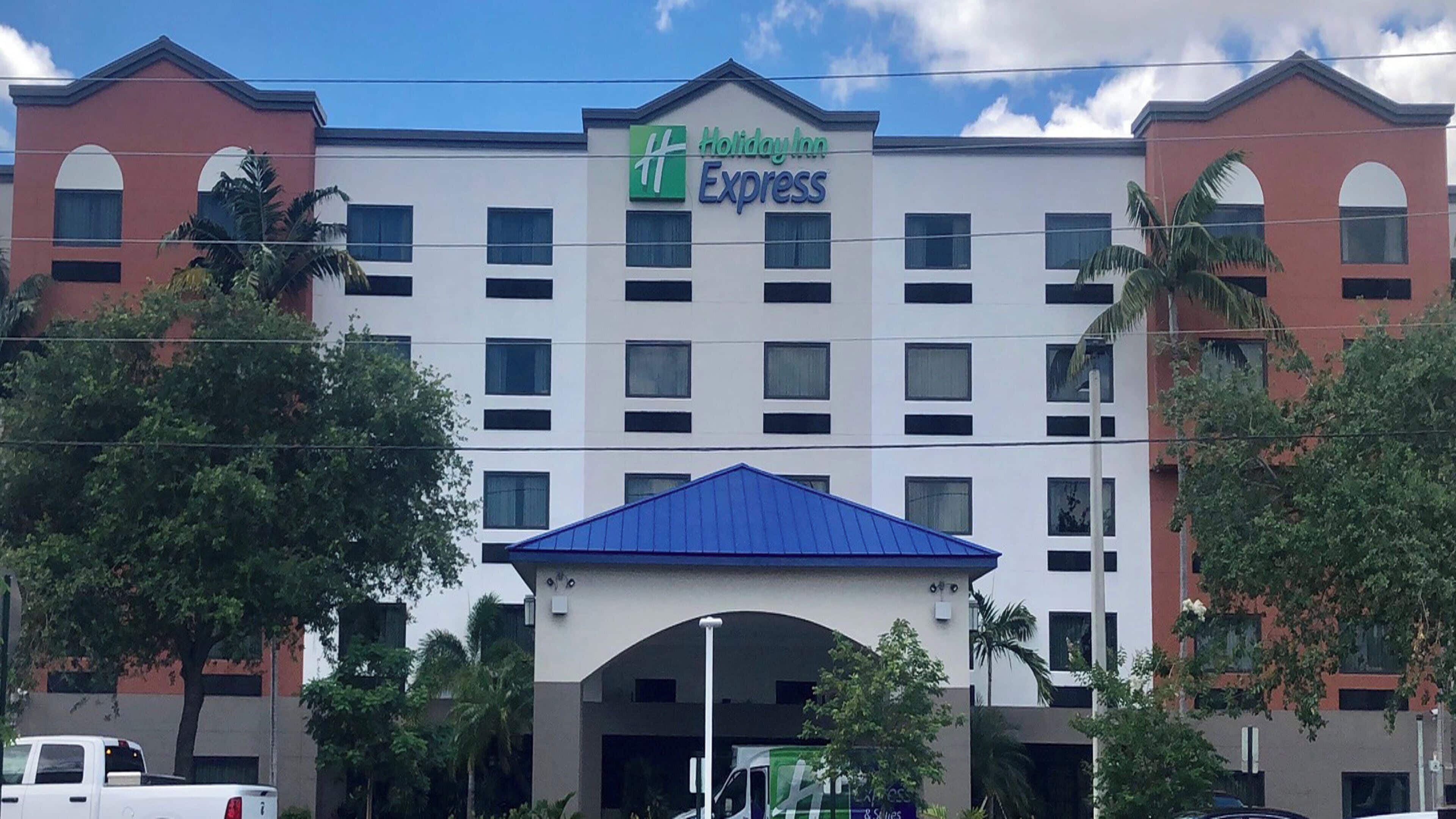 A Holiday Inn Express building with a central entrance, multiple windows, and a blue roof.