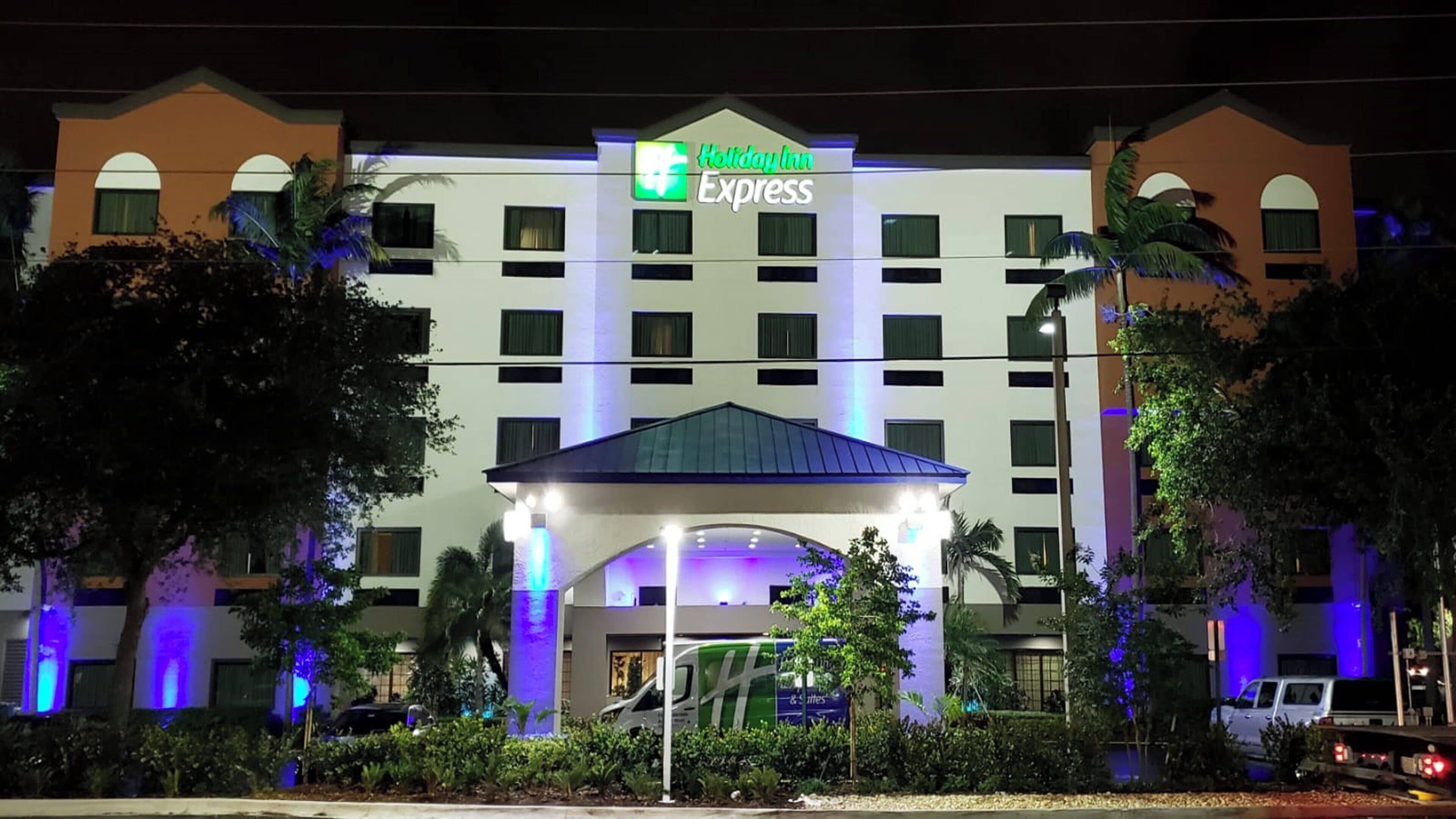 Een Holiday Inn Express hotel met een centrale ingang, meerdere verdiepingen en een parkeerplaats.