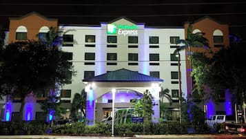 Een Holiday Inn Express hotel met een centrale ingang, meerdere verdiepingen en een parkeerplaats.