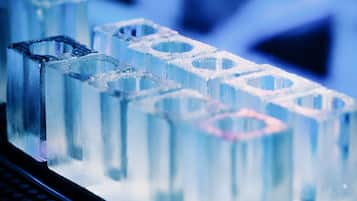 Primer plano de cubitos de hielo con un patrón hexagonal, sobre una superficie con un teclado al frente.