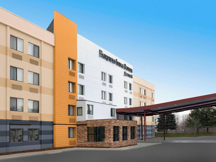 Un hotel con fachada moderna, múltiples ventanales y un área de acceso cubierta.