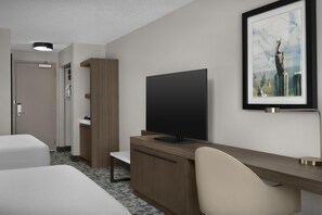 A hotel room with a bed, a desk with a computer, a chair, a television, and a framed picture on the wall. - Hilton Garden Inn Hilton Head (Hilton Head Island)