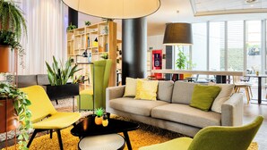 Una sala de estar moderna con un sofá, sillas, una mesa de centro y una estantería.