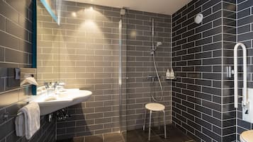 Une salle de bain moderne avec une douche à parois de verre, un lavabo blanc et des toilettes.
