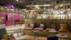 Een moderne lounge met leren banken, een houten bankje en een schaaktafel.