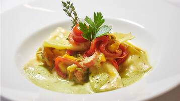 A plate of food with pasta, tomatoes, and a garnish.