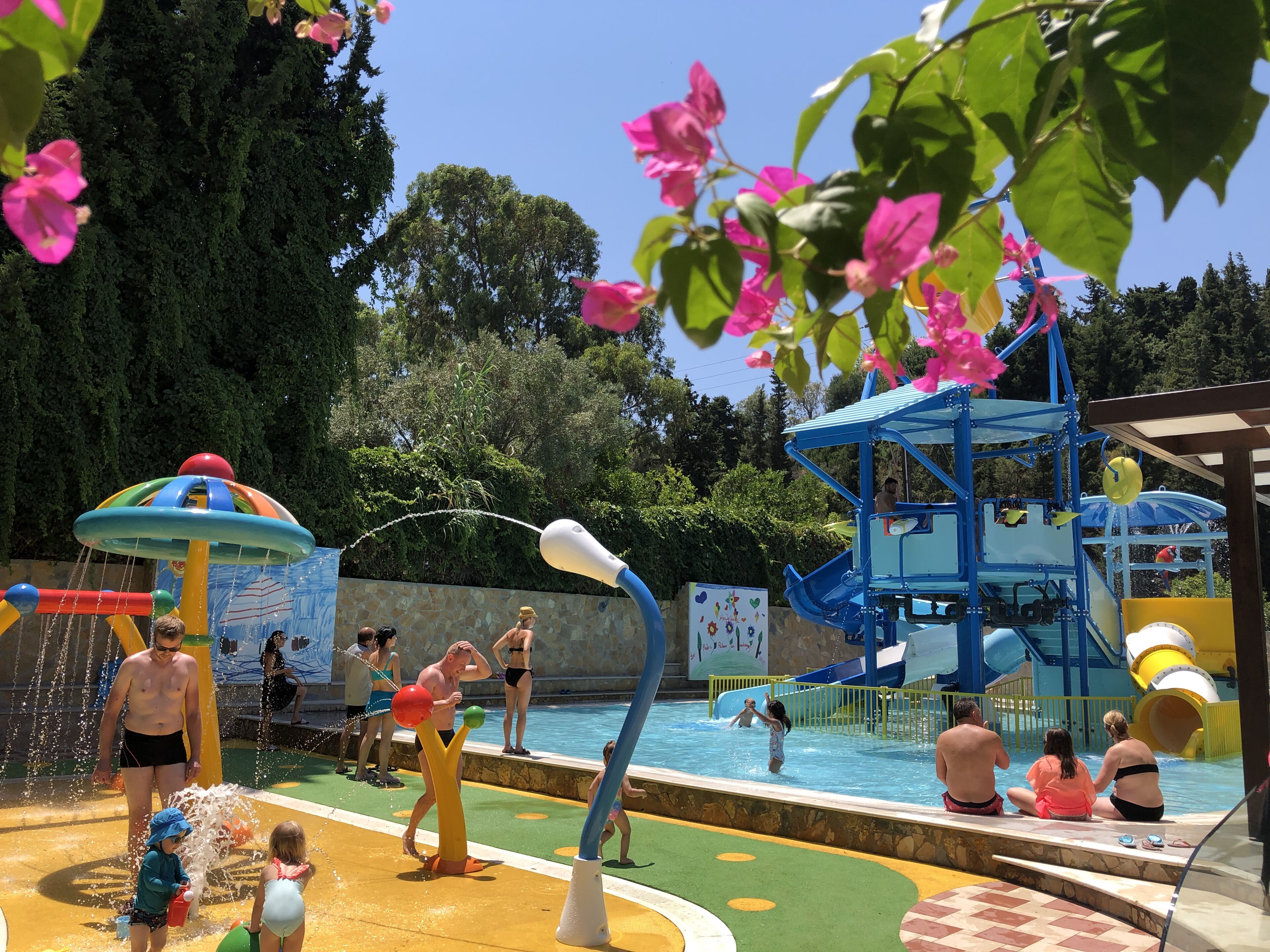 A water park with a pool, slides, and play structures.