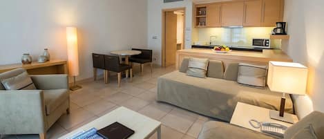 Un salon moderne comprenant un canapé, une table basse et un coin repas avec une table et des chaises.
