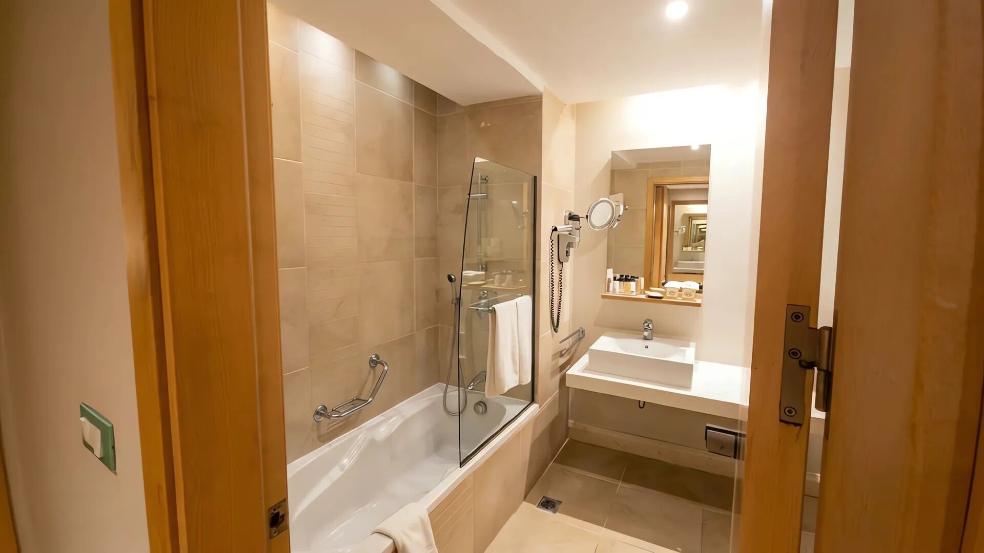 A modern bathroom with a glass-enclosed shower, a standalone bathtub, and a vanity with a mirror.