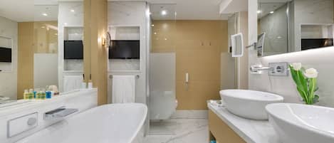 Un baño moderno con una bañera grande, dos lavamanos y una zona de ducha.