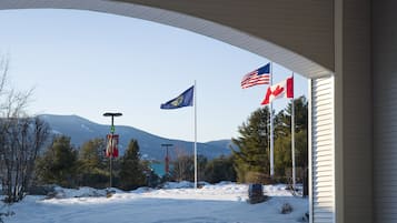 Un paisaje nevado con banderas, incluyendo las banderas de Canadá y de Estados Unidos, bajo un puente.