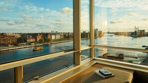 A modern room with large windows overlooking a river and cityscape. - Copenhagen Marriott Hotel (Copenhagen)