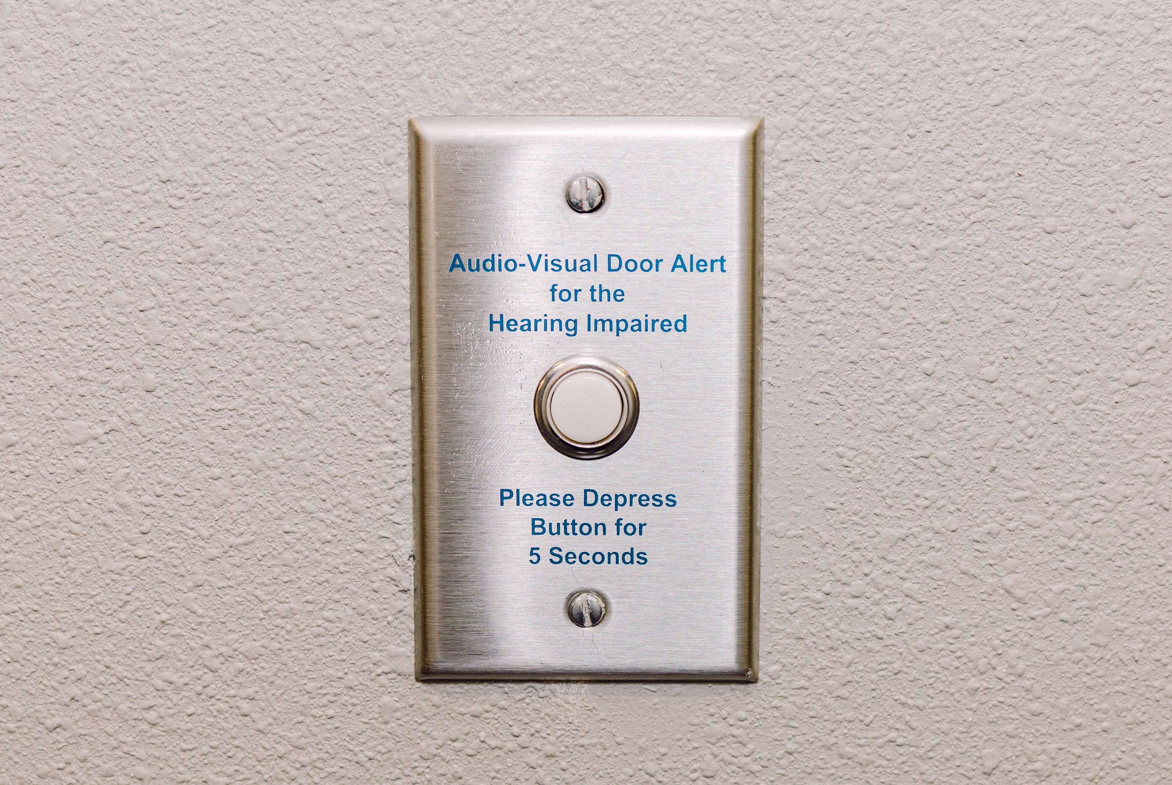 A doorbell with instructions for hearing-impaired individuals to depress the button for 5 seconds.