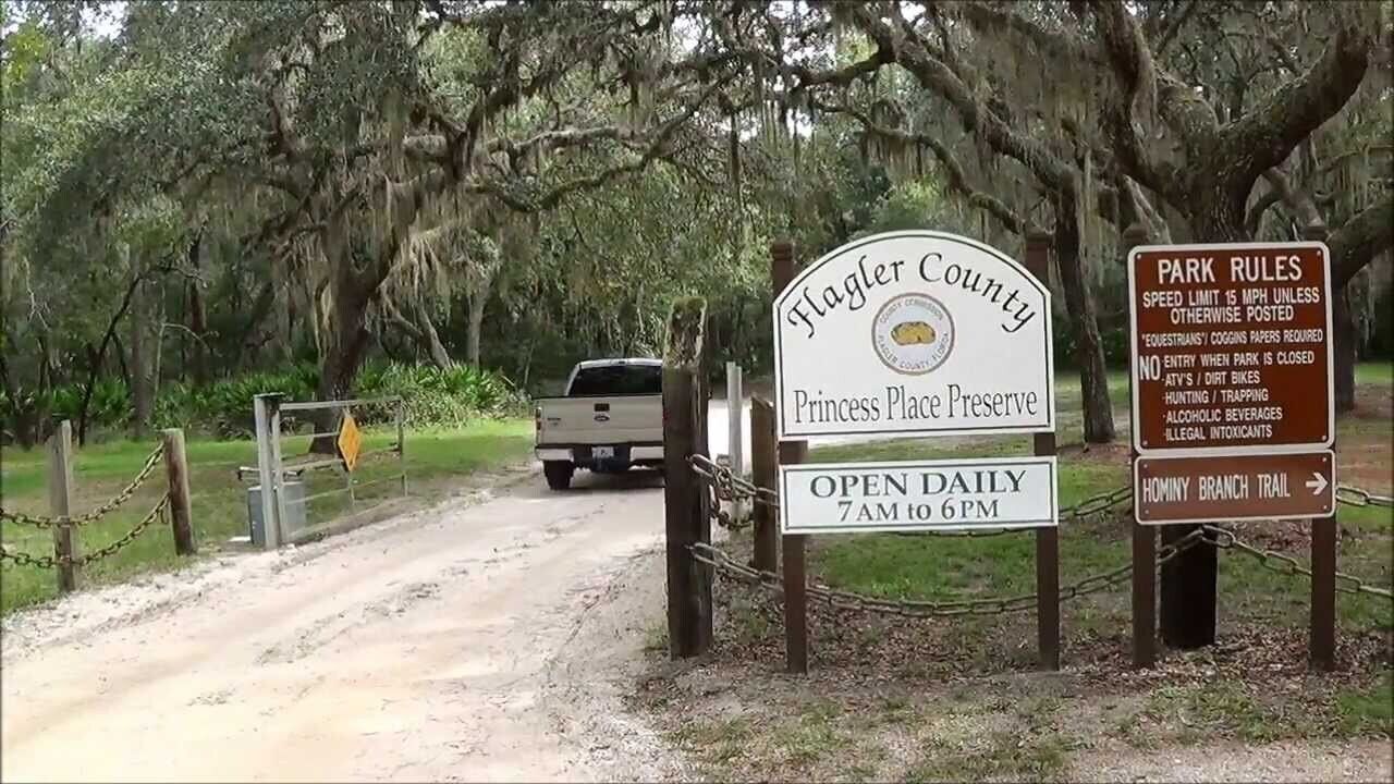 A sign for Flagler County Princess Place Preserve with park rules and an open daily sign.