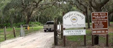 A sign for Flagler County Princess Place Preserve with park rules and an open daily sign.