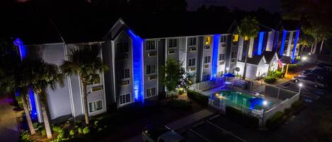 Un hotel de varios pisos con piscina y zona de estar al aire libre.