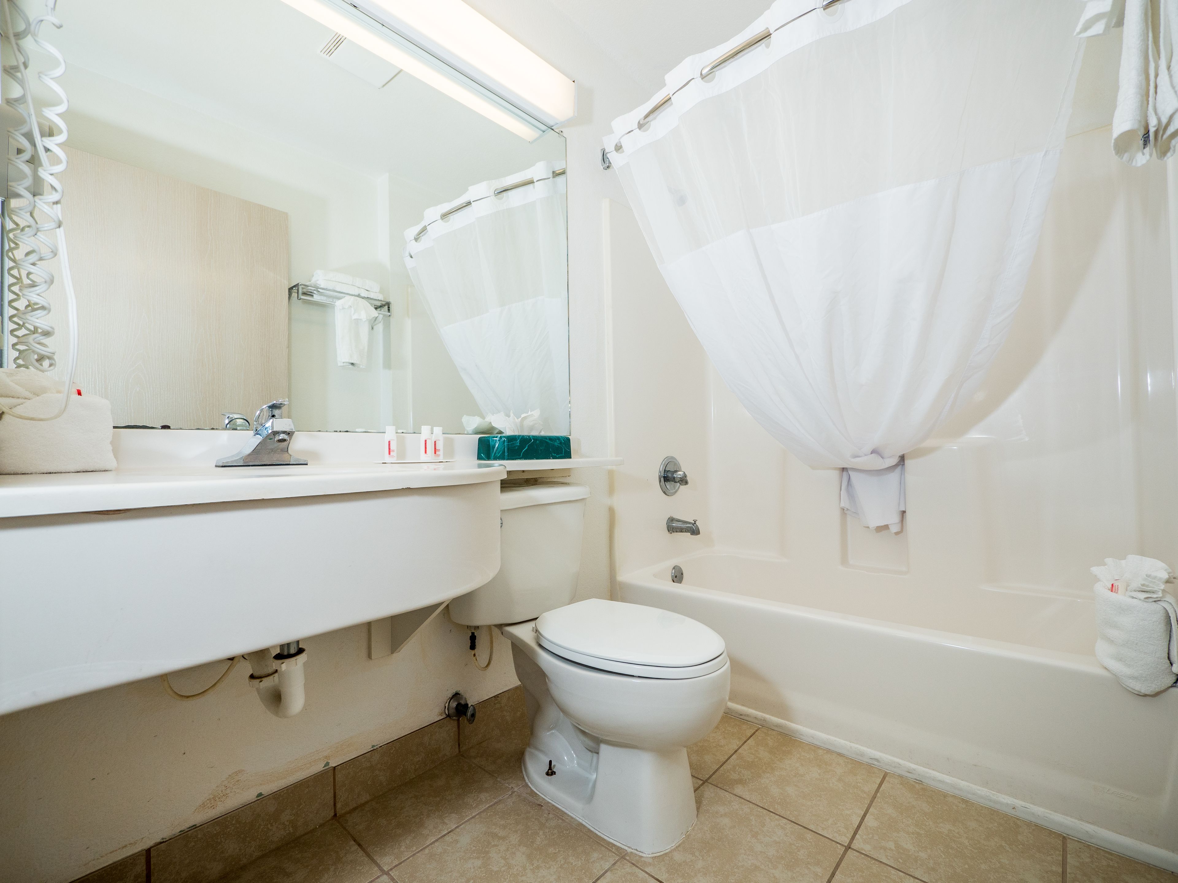 A bathroom with a toilet, sink, and bathtub.