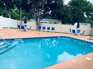 Una piscina al aire libre, sombrillas