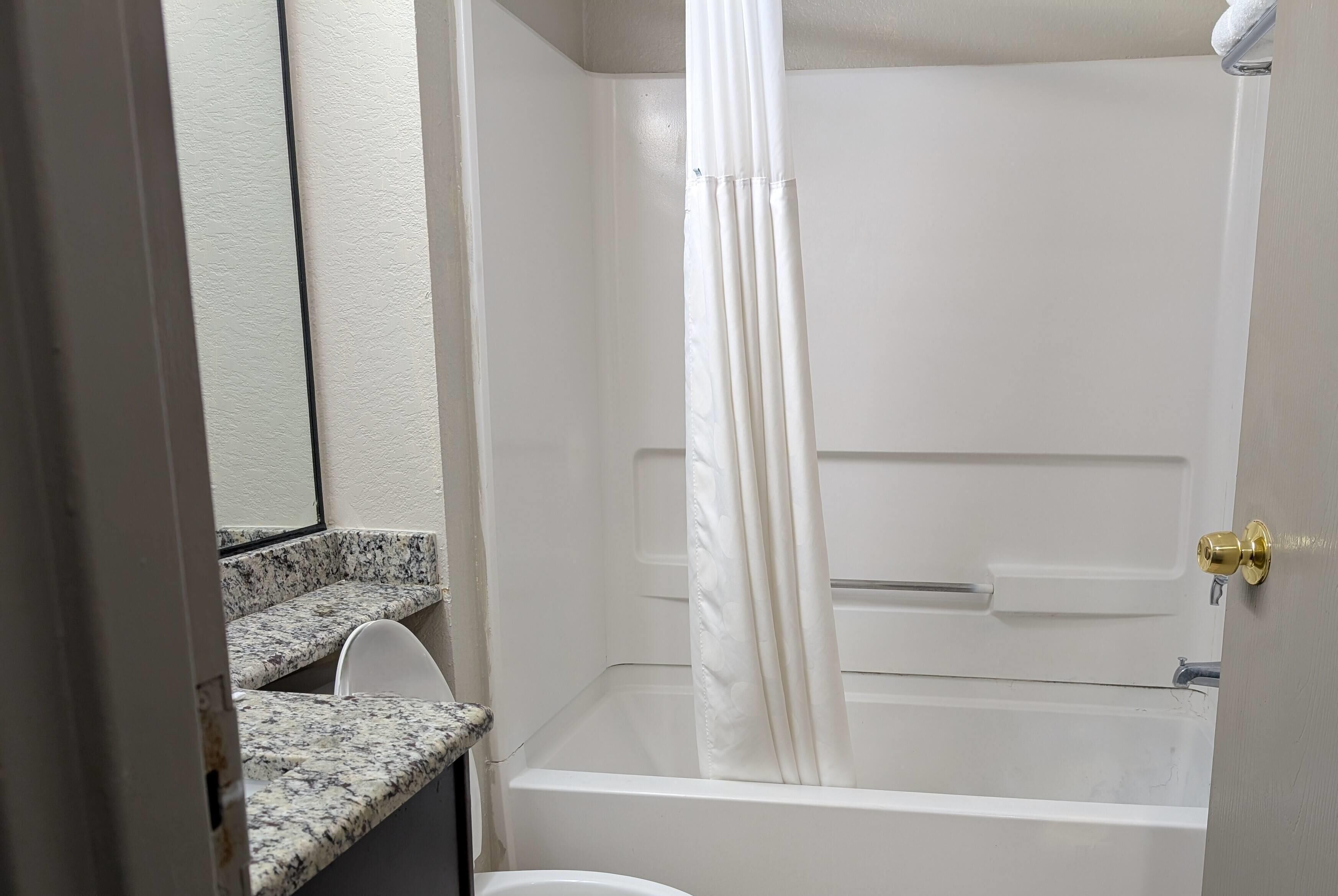 Un baño con bañera, inodoro y cortina de ducha.