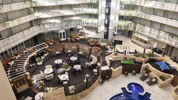 A multi-level atrium with a pool, seating areas, and a reception desk.