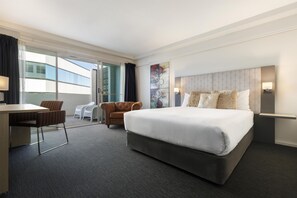 A hotel room with a large bed, a desk, two chairs, a view of the outside, and a modern headboard. - Best Western Plus Hotel Lord Forrest (Bunbury)