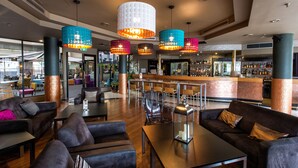 A modern lobby with leather sofas, a bar area, and colorful hanging lamps. - Best Western Plus Hotel Lord Forrest (Bunbury)