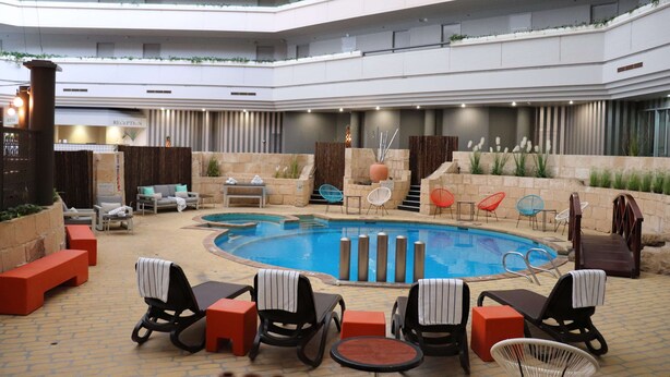 A modern indoor pool area with lounge chairs and a reception desk. - Best Western Plus Hotel Lord Forrest (Bunbury)