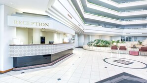 A modern reception area with a reception desk, seating area, and multiple floors with greenery. - Best Western Plus Hotel Lord Forrest (Bunbury)