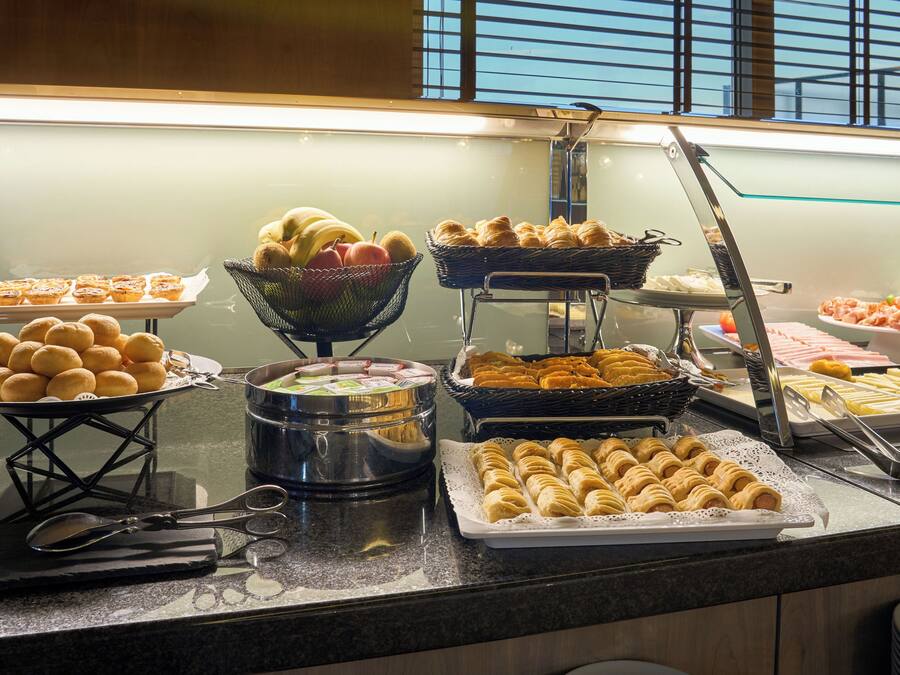 A buffet with various food items including pastries, fruits, and desserts.