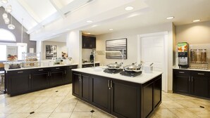 A modern kitchen with dark cabinetry, a large island, and a coffee machine. - Residence Inn by Marriott Monroe (Monroe)