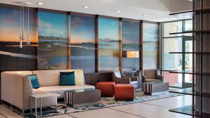A modern lobby with a sofa, chairs, and a large mural of a landscape. - Residence Inn by Marriott Irvine John Wayne Airport (Irvine)