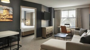 A modern hotel room with a bed, a desk, a sofa, and a TV. - Residence Inn by Marriott Irvine John Wayne Airport (Irvine)
