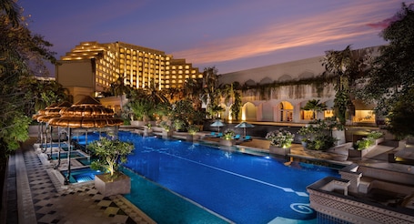 Una piscina al aire libre, sombrillas, sillones reclinables de piscina