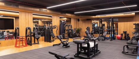 A gym with various exercise equipment, wooden walls, and a tiled floor.