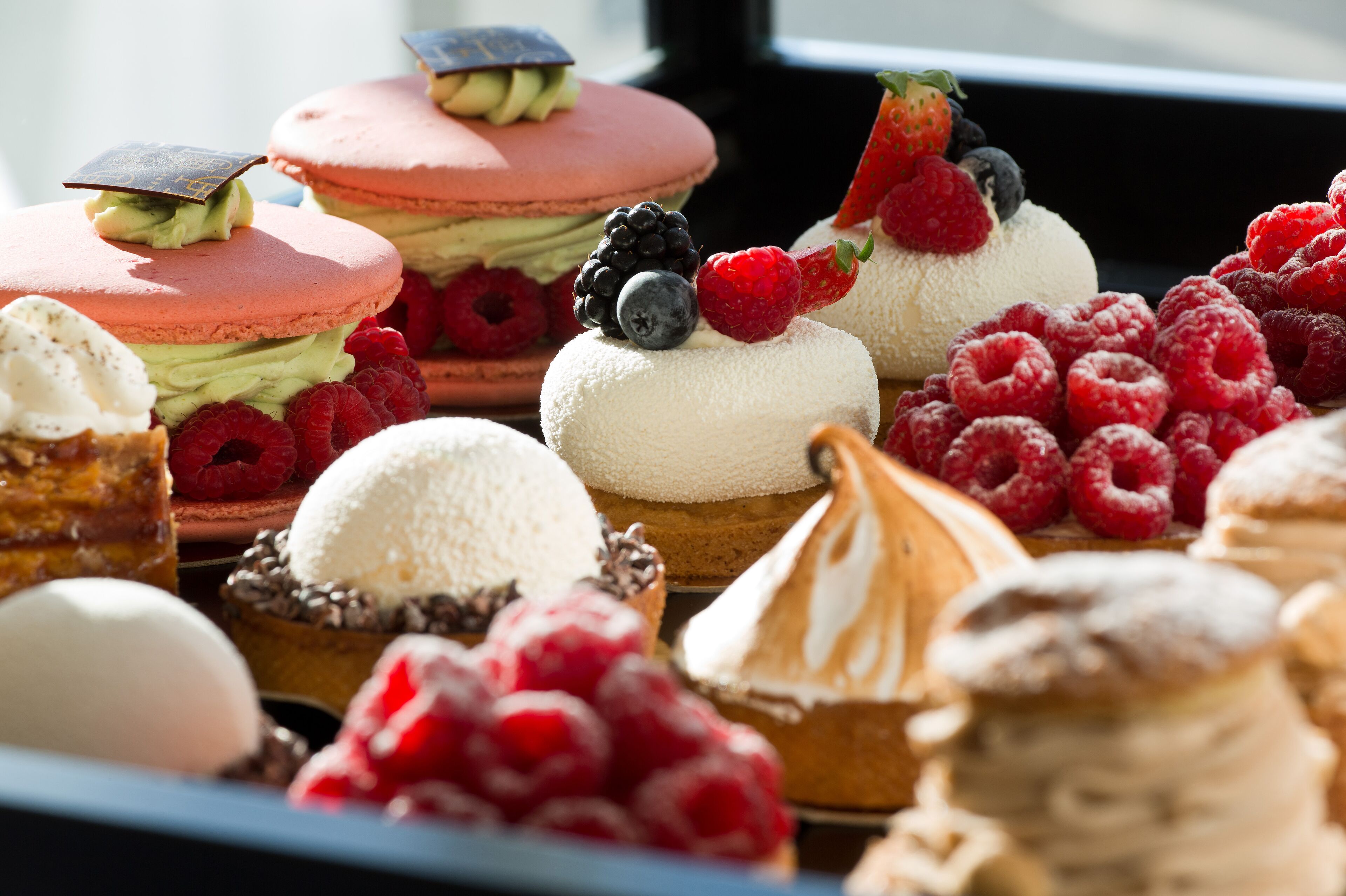 Diversas opciones de postres, incluyendo macarons, helado y pastelería con frutos frescos.