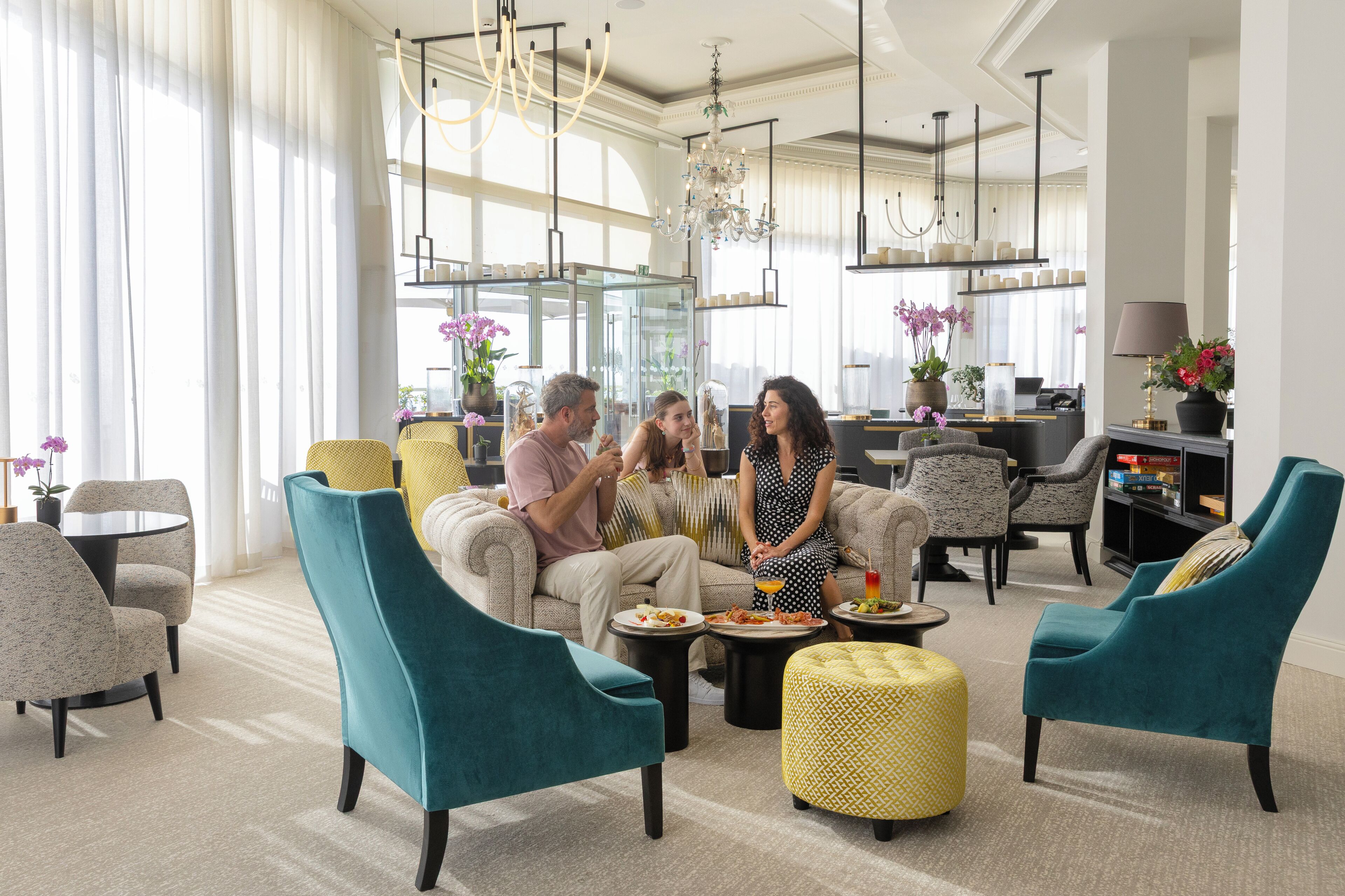 A modern living room with a sofa, chairs, a coffee table, and a dining table.