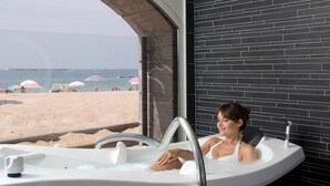 A bathtub with a view of a beach and umbrellas. - Grand Hôtel Spa & Thalasso à Saint-Jean-de-Luz (Saint-Jean-de-Luz)