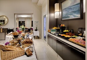 Ein Buffet mit verschiedenen Speisen, ein Spiegel und ein Gemälde an der Wand.