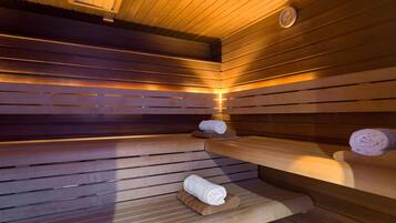 Un sauna avec des bancs en bois et des serviettes disposées sur ces bancs.