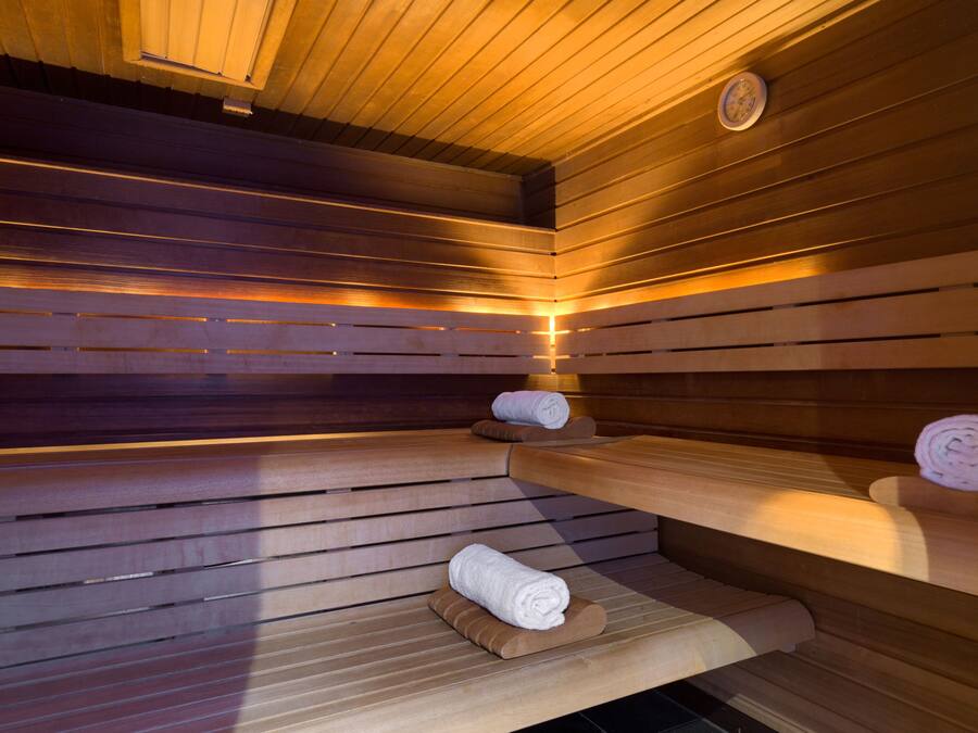 Un sauna avec des bancs en bois et des serviettes disposées sur ces bancs.