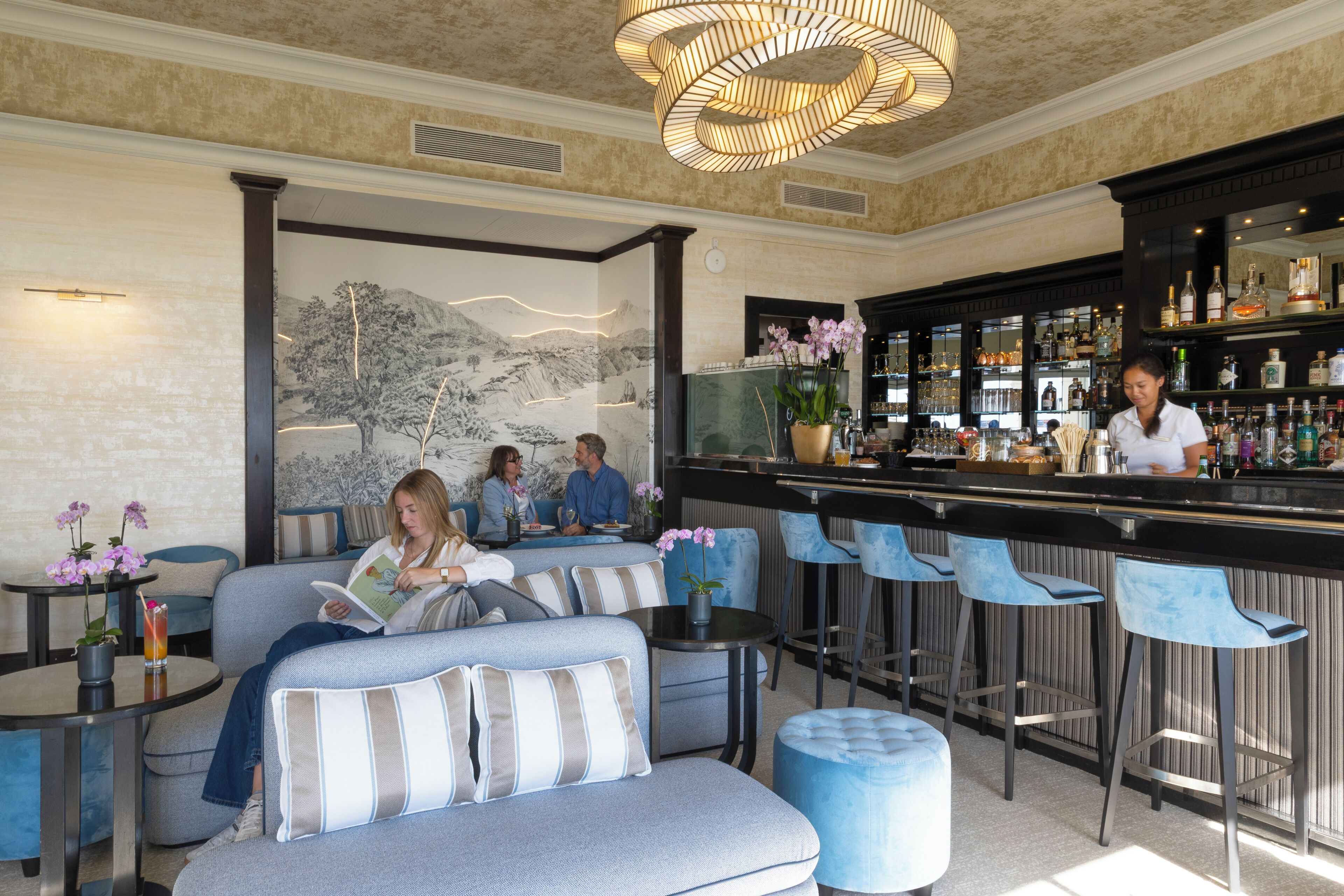 A bar area with seating, a bar counter, and a mural on the wall.