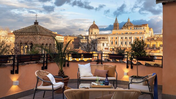 A rooftop terrace with outdoor seating, a view of historic buildings, and a clear sky. - Hotel Viminale (Rome)