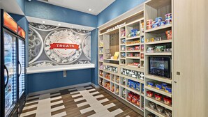 A snack and treat section with a variety of products on shelves and a wall display. - Hampton Inn & Suites Los Angeles/Hollywood (Los Angeles)