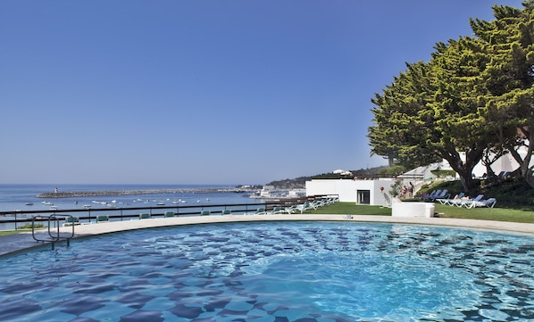 Piscine extérieure, parasols de plage, chaises longues