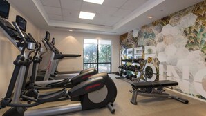 A gym with treadmills, a rowing machine, and dumbbells. - SpringHill Suites by Marriott Charlotte Concord Mills Spdwy (Concord)