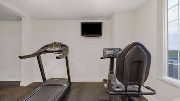 A home gym with a treadmill and an elliptical machine.
