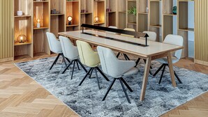 A dining area with a long table, six chairs, and wooden shelving units with various items. - Holiday Inn Prague Congress Centre by IHG (Prague)
