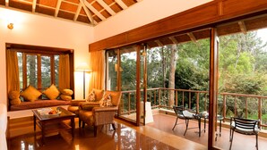 A spacious living area with a sofa set, a coffee table, and a balcony with outdoor seating. - Gateway Chikmagalur (Chikkamagaluru)